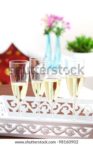 Sparkling wine on the table with flowers in background