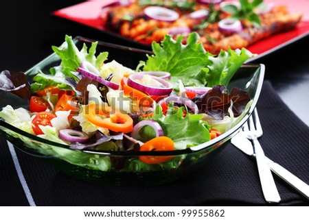 Mixed vegetable salad grilled meat in background