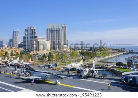 SAN DIEGO,USA - FEBRUARY 24 2014: The historic aircraft carrier, USS Midway, now a museum docked in Downtown San Diego, Southern California, United States of America, the skyline and Coronado bridge.