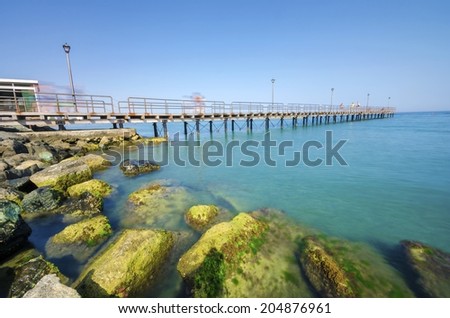 The Limassol pier in Enaerios Area in Cyprus. A day view of the Mediterranean sea, the rocks on the coast of Limassol city and a local coffee shop.