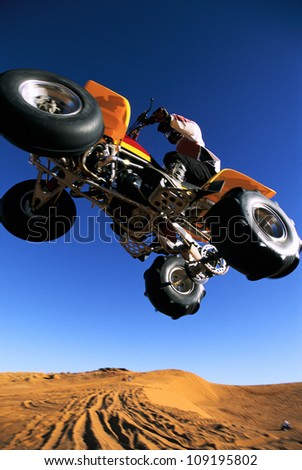 A man on a four wheeler flying through the air