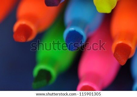 Orange, yellow, blue, green and pink highlighters with a blue background