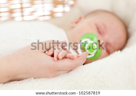 parent\'s hand keeping newborn baby\'s one