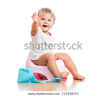 smiling baby sitting on chamber pot with toilet paper roll