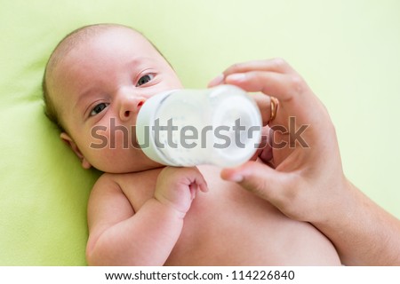 father feeding milk his baby infant from bottle