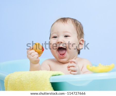 adorable child boy taking bath in blue tub
