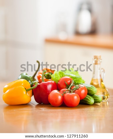 Healthy food fresh vegetables  and bottle with oil on the kitchen table