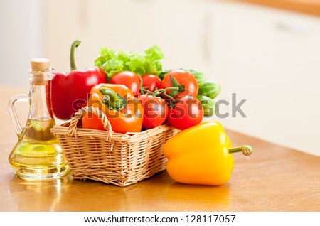 Healthy food fresh vegetables in basket and bottle with oil on the kitchen table