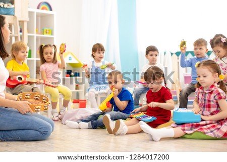Kindergarten children playing different musical toys. Early musical education in day care centre