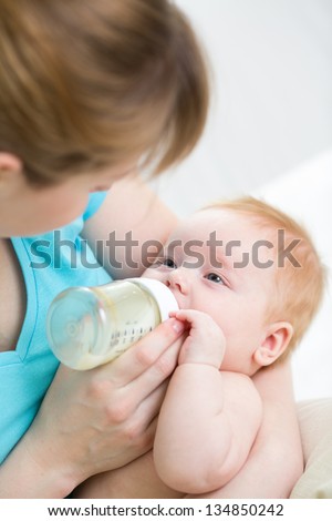 mother feeding baby from bottle