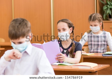schoolchildren with protection mask against flu virus at lesson