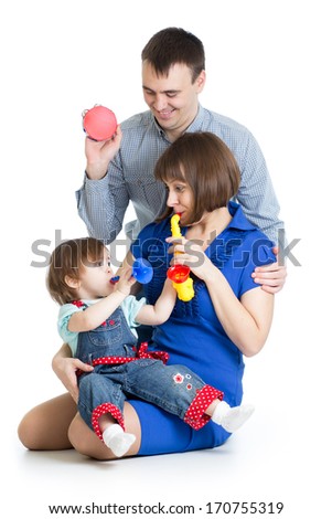 Mother, father and baby girl play musical toys. Isolated on white background