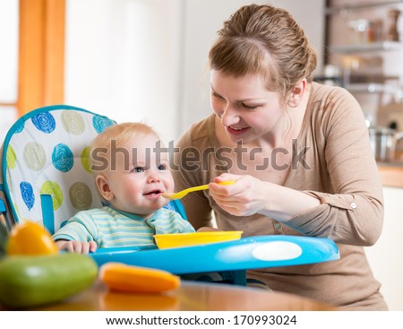 Mom Feeds Baby Boy With Spoon