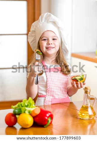 Chef girl preparing and tasting healthy food over white background
