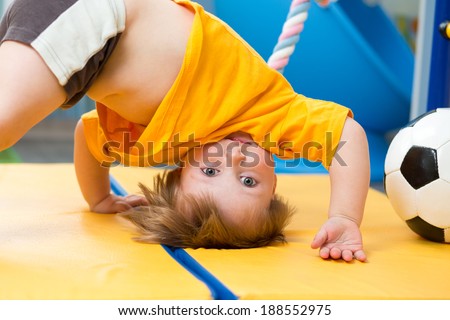 baby standing upside down on gym mat