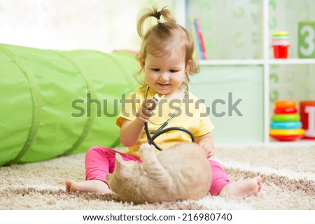 Kid girl playing doctor with kitten