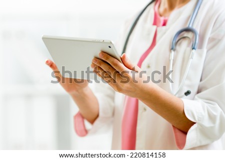 Doctor in hospital office using a digital tablet