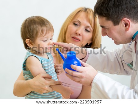 Pediatrician counseling mother and her son about nasal irrigation or douche with neti pot