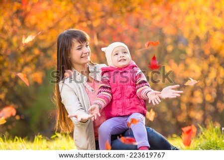 beautiful mother with kid girl outdoors in fall