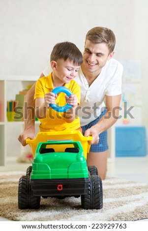 kid boy and his dad playing with toy trunk