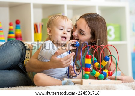 kid and mother play with educational toy indoor