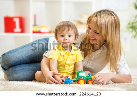kid boy and woman playing with toy indoor