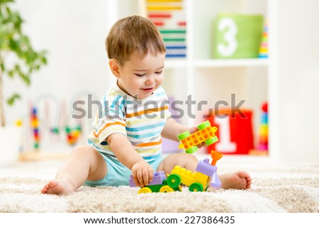 kid boy playing with building blocks at home or kindergarten