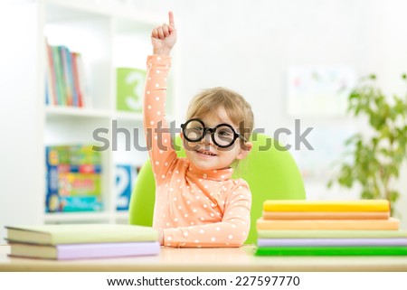 Portrait clever kid child girl with books indoors