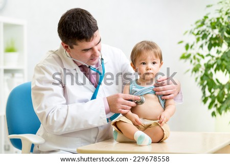 doctor man examining heartbeat of kid boy with stethoscope