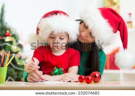 child girl and mom writing christmas letter to Santa Claus