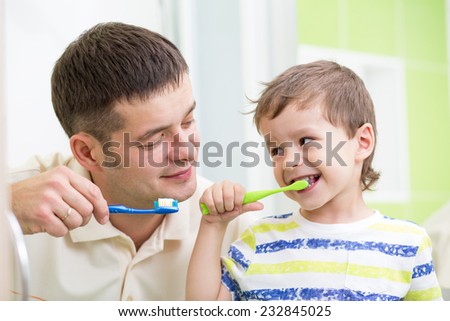 father and kid brushing teeth in bathroom