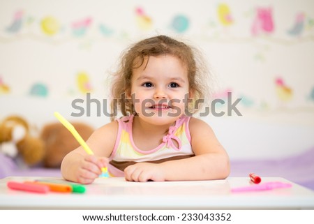 kid girl paints in her nursery at home