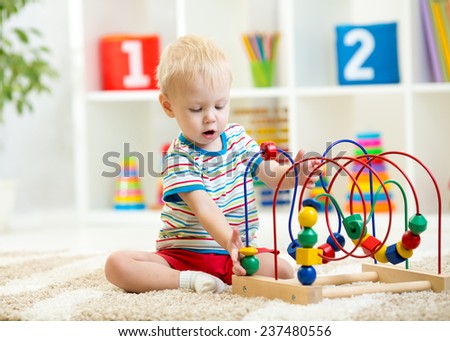 funny child playing with educational toy indoors