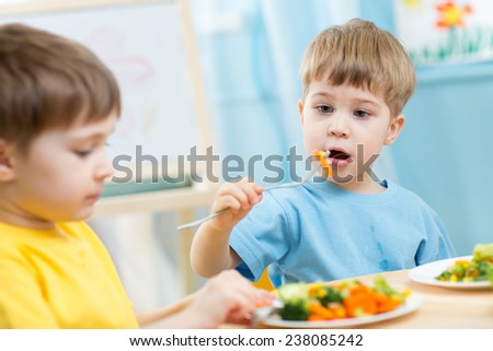 kids boys eating healthy food in kindergarten or at home
