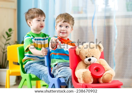 Two cute little boys playing role game in daycare