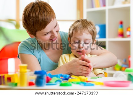 child boy and woman play colorful clay toy at playroom