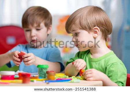 kids playing with play clay at home or kindergarten or playschool