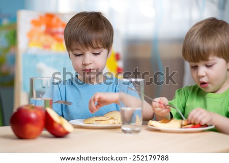 kids eating healthy food at home or kindergarten
