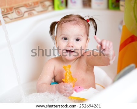 funny toddler baby smiling while taking a bath