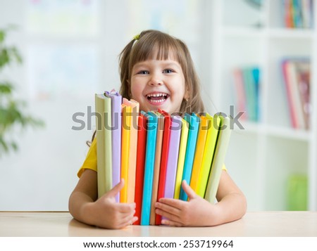 Cute kid girl preschooler with books at home