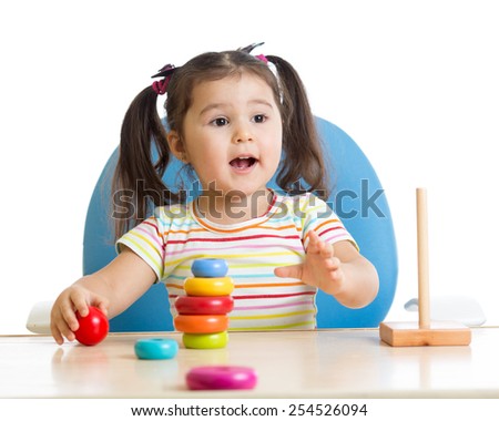 child girl playing with color pyramid toy