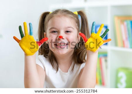 cute cheerful child girl with painted hands and face