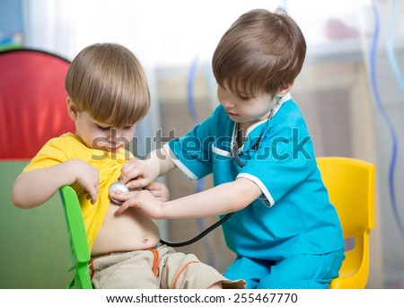 child boy weared as doctor role playing with his younger brother