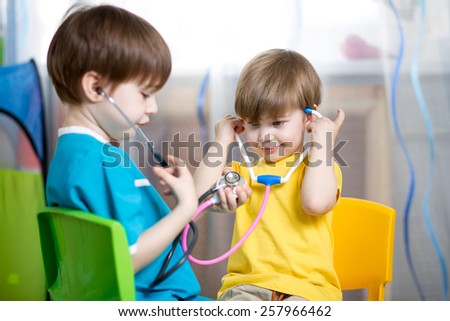 kid boy weared as doctor role playing with his younger brother