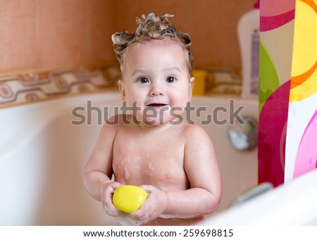 funny baby girl smiling while taking a bath