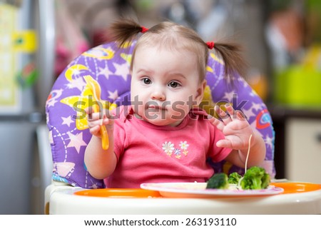cute kid girl eating food on kitchen