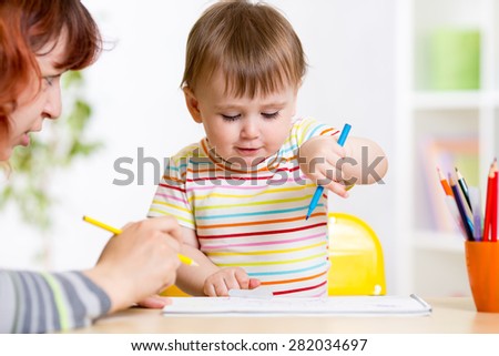 child girl painting in nursery at home
