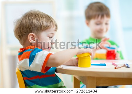 children play and paint at home or kindergarten or playschool or daycare