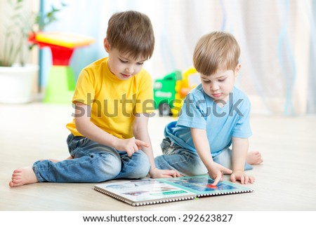 brothers kids read book together at home