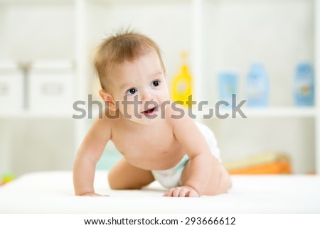 Cute smiling baby on all fours in diaper or nappy